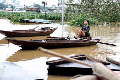 Vietnam Typhoon Yagi: A woman paddles a boat on a flooded street in Hanoi